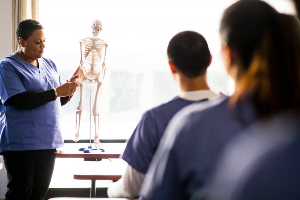 The Students in a classroom are being instructed in Medical Assistant training by an Expert.