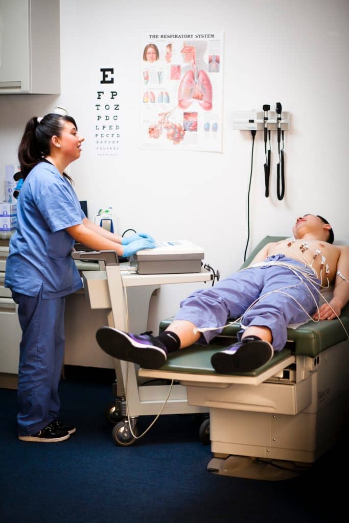 A Medical Assistant using her Medical school training to assist a patient.