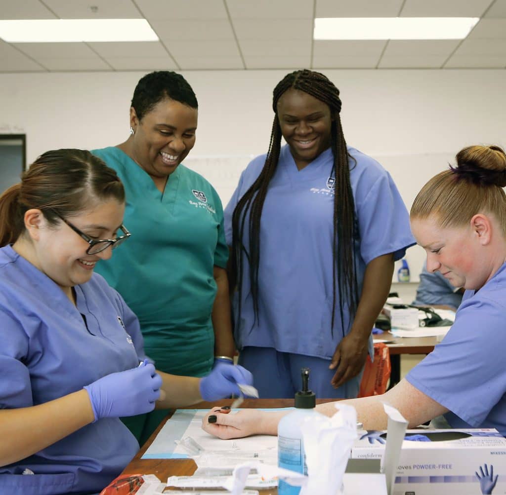 A picture of students and teachers engaging in an interactive session during BAMA Medical Assistant Training.