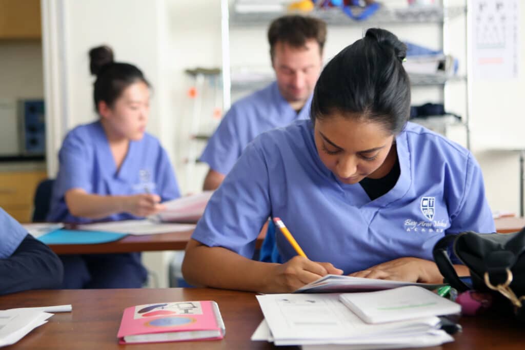 A Young student carefully examines which training is right for her. MA vs Phlebotomist program.