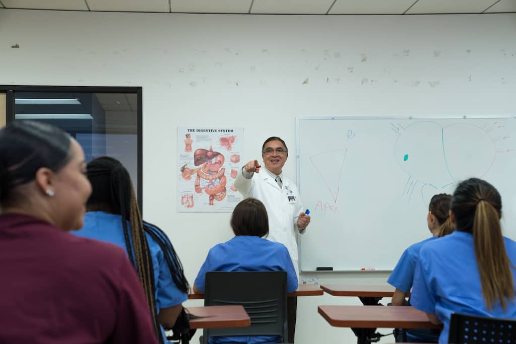 A classroom of medical students paying keen attention to their professor.