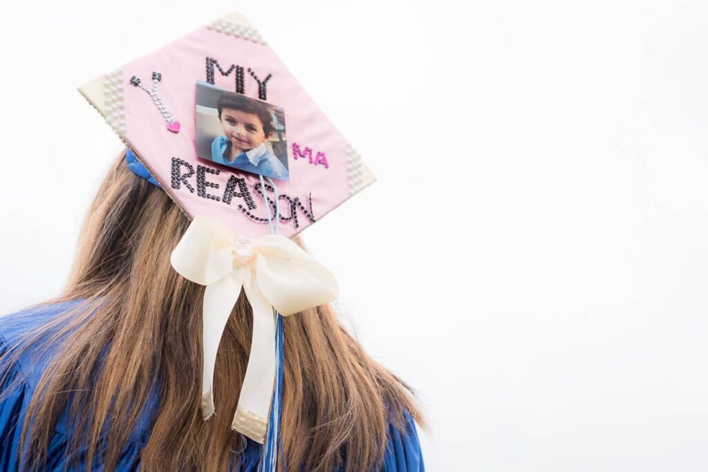 A Graduate has decorated her cap with the picture of her child with the caption " My Reason"
