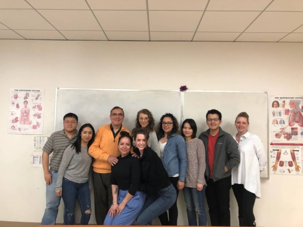 Students and teachers together taking a picture in the classroom.